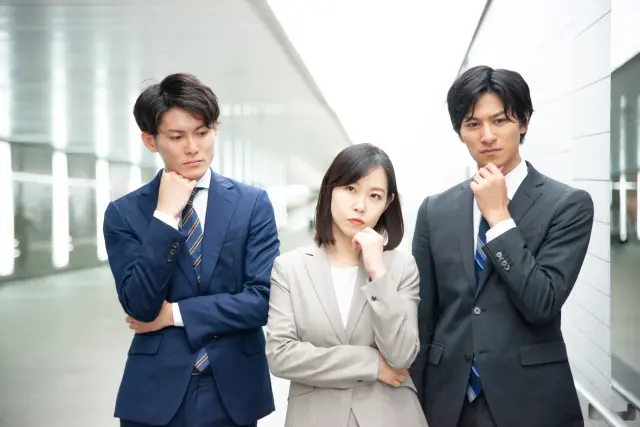 疑問を抱えるスーツ姿の男女
