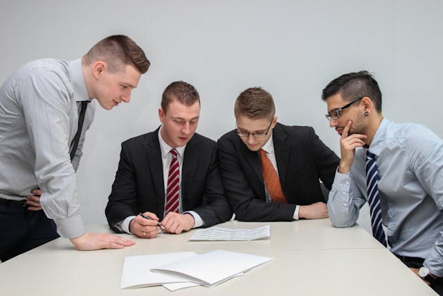書類を見て話し合う4人の男性